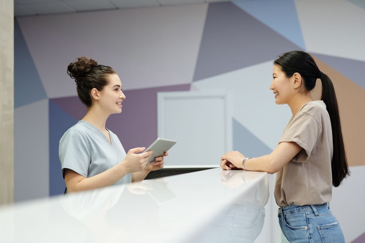 Patient talking with a dental receptionist at the front desk