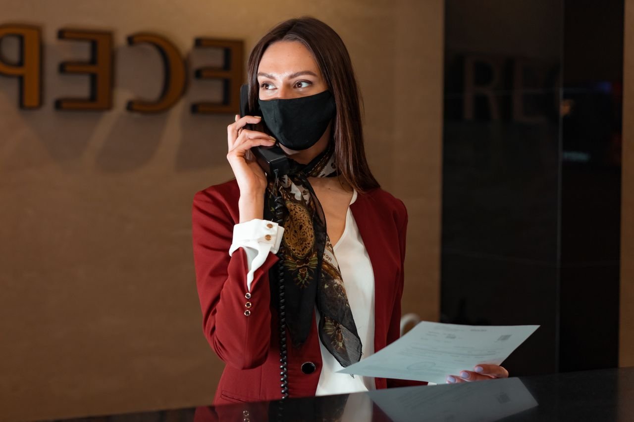 Dental receptionist on the phone calling patients to book overdue appointments